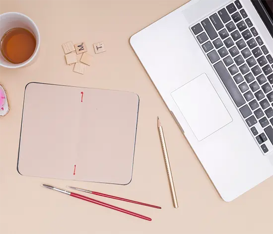 Workspace creativo di design con laptop, palette colori e sketch UI